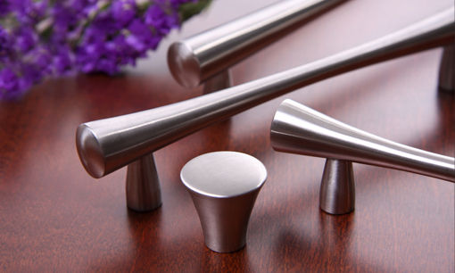 A group of four handles and one knob on top of a table.