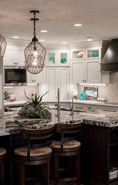 A kitchen with white cabinets and island in it